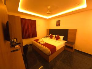 a bedroom with a bed and a television in it at Shreem Sesha Sai Residency in Tiruvannāmalai +21 photos