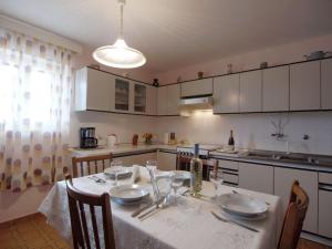 a kitchen with a table with a white table cloth on it at Apartments Lukoran in Lukoran +28 photos