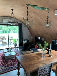 a living room with a wooden table and chairs at Tinyhouse in Bakkeveen in Bakkeveen +6 photos