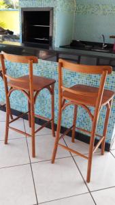 zwei Holzstühle neben einer Küchentheke in der Unterkunft Casa mobiliada tipo chácara para cop30 in Benfica