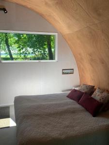 a bedroom with a large bed with a large window at Tinyhouse in Bakkeveen in Bakkeveen
