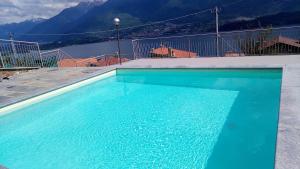 a blue swimming pool with a view of a mountain at Casa bella vista Emma lago Como in Vercana
