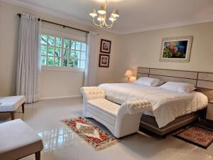 a bedroom with a large white bed and a chair at A Casa Serena in Morro Reuter