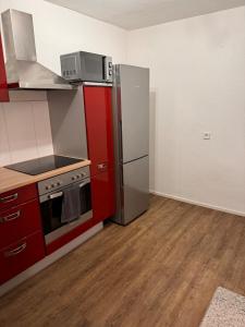 a kitchen with a stainless steel refrigerator and red cabinets at Rebhof Bahlingen Ferienwohnung Nr 17 Silvaner in Bahlingen