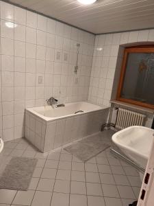 a bathroom with a bath tub and a sink at Rebhof Bahlingen Ferienwohnung Nr 17 Silvaner in Bahlingen
