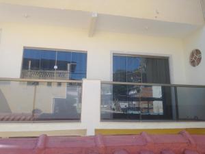 an empty balcony with windows and chairs in a building at Casa 2 quartos com ar condicionado e próximo ao centro in Cachoeiro de Itapemirim