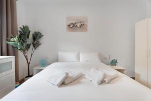 a bedroom with a white bed with two pillows on it at Apartamento Delfin Amarillo in Santiago del Teide