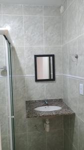 une salle de bains avec un lavabo et un miroir dans l'établissement Apartamento Brisa 201, à Pedra de Guaratiba