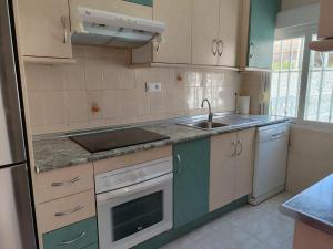 a kitchen with a sink and a stove at Casa La Mata in Torrevieja