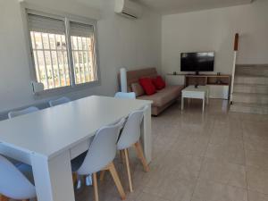 a living room with a table and chairs and a couch at Casa La Mata in Torrevieja