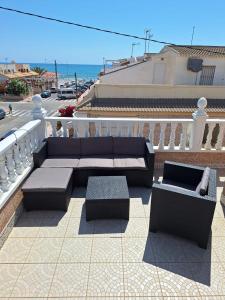 a patio with couches and tables on a balcony at Casa La Mata in Torrevieja
