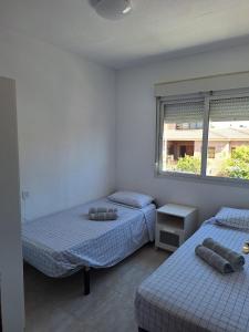 a bedroom with two beds and a window at Casa La Mata in Torrevieja