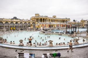 a large building with a large pool of people in it at Little Americas National Parks Apartments in Budapest