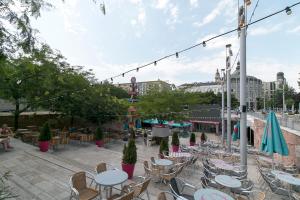 an outdoor patio with tables and chairs and people sitting at Little Americas National Parks Apartments in Budapest