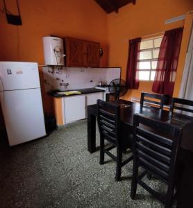 eine Küche mit einem Tisch und einem weißen Kühlschrank in der Unterkunft Deptos Pablos, Apto No 4 in Villa Gesell