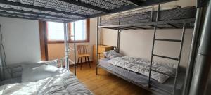a bedroom with two bunk beds and a chair at Résidence Le Dôme - maeva Home - Appartement 3 pièces 6 personnes - Confort MAE-6221 in La Mongie