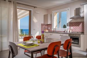 a kitchen and dining room with a table and chairs at Villa Orizzonte in Scopello