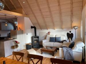 a living room with a white couch and a stove at Maison Atypique in Charmey