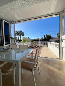 a white dining table and chairs on a patio at "Ancla-Blanca" Ocean View Duplex 2min Beach Cabo Roig - La Zenia in Orihuela Costa