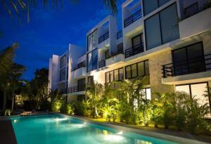 a swimming pool in front of a building at night at Anah Tulum Country Club in Akumal