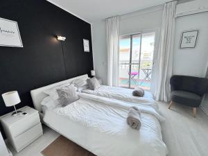 sypialnia z łóżkiem, krzesłem i oknem w obiekcie Laguna Beach, Todos los Santos w mieście Torrox Costa