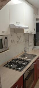 a kitchen with a stove top and a microwave at Apartament vacanta in Sibiu