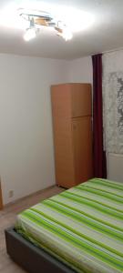 a bedroom with a green and white bed and a dresser at Apartament vacanta in Sibiu