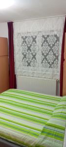 a bedroom with a bed with a green and white blanket at Apartament vacanta in Sibiu