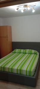 a bed with a green and yellow striped comforter in a bedroom at Apartament vacanta in Sibiu +3 photos