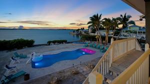 a blue and pink slide on the beach near the water at Infinite Horizons by Last Key Realty in Stock Island