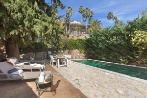 a backyard with a swimming pool and a table and chairs at Can Palou in Fornalutx