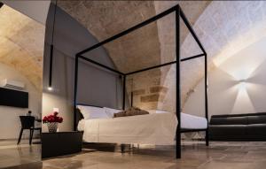 a bedroom with a black canopy bed and a chair at La Dimora di Cesare Braico in Brindisi
