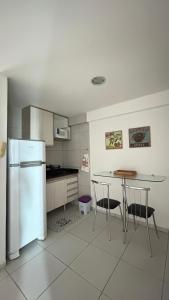 a kitchen with a refrigerator and a table and chairs at West Flat Studio80 na Nova Betânia- INNOVA in Mossoró