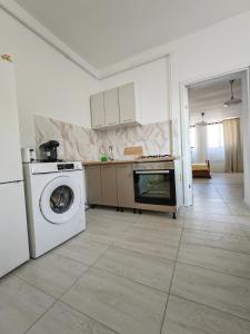 een keuken met een wasmachine en een wasmachine bij Central Apartments Madona in Craiova