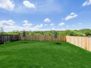 a backyard with a fence and a green lawn at Family Modern Oasis Lackland BMT Family Home 3 Bed 2 Bath in San Antonio