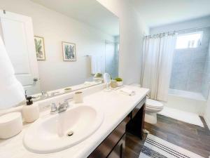 a white bathroom with a sink and a toilet at Family Modern Oasis Lackland BMT Family Home 3 Bed 2 Bath in San Antonio +52 photos