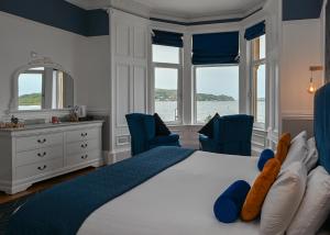 una camera da letto con un grande letto con due sedie blu di MacKays a Oban