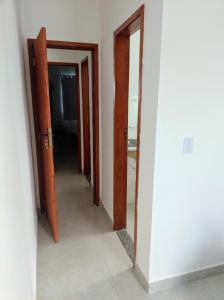 カボ・フリオにあるOndas do Peróの部屋に3つの開いたドアがある廊下
