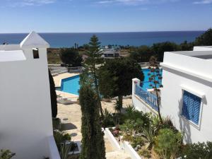 uitzicht op het zwembad vanaf het balkon van een huis bij Ikaria Village Studio in Paphos City