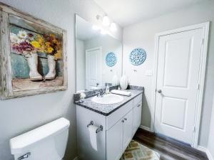 a bathroom with a sink and a painting on the wall at Family Cottage Cozy Family Gem near SeaWorld Lackland in San Antonio +37 photos