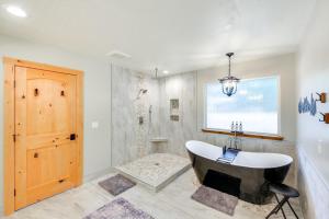 a bathroom with a bath tub and a window at Charming Idaho Home with Hot Tub, Near Beaches! in Sagle +33 photos