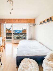 Un dormitorio con una cama y una ventana grande. en Center of Veysonnaz with a View !, en Veysonnaz