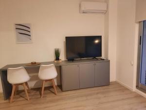 a living room with a desk with a tv and two chairs at Recoleta, cómodo, cerca de todo, WiFi, Balcón in Buenos Aires