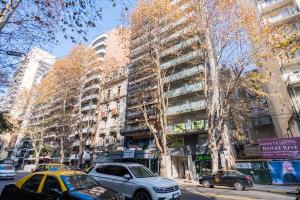 a city street with cars parked in front of a tall building at Recoleta, cómodo, cerca de todo, WiFi, Balcón in Buenos Aires