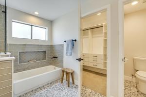 a bathroom with a tub and a toilet and a sink at 1 Mi to Grand Ave Modern Home with Spacious Yard! in Phoenix +19 photos