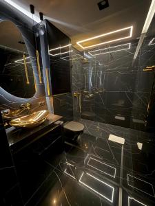 a black bathroom with a toilet and a sink at Wiślane Tarasy 2 VIP Apartamenty JACUZZI in Krakow
