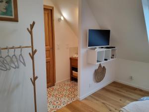 a small room with a tv and a bedroom at Chambres Le Penty in Pleumeur-Bodou