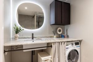 ein Badezimmer mit Waschbecken und Waschmaschine in der Unterkunft Nordic Gem in Stockholm