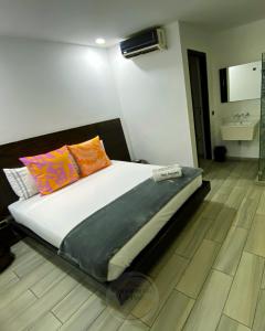 a bedroom with a bed with colorful pillows on it at Hotel Panorama Urban Medellin in Medellín