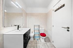 bagno con lavandino e servizi igienici con sedile rosso di Petit Campanário a Campanário Altre 9 foto